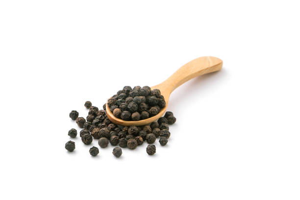 istock Black pepper or peppercorns in wooden spoon with floor. 1460151518