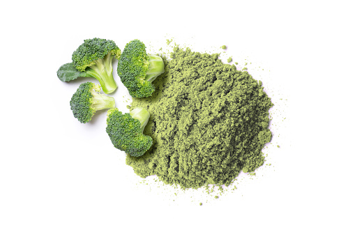 Fresh Broccoli and green herbal powder isolated on white background. Top view, flat lay.
