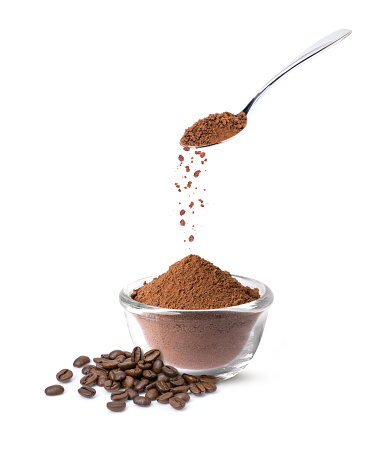 Pouring instant coffee or coffee powder from stainless teaspoon isolated on white background.