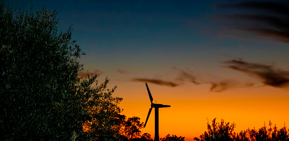 Wind Farm Silhouette. Energy Windmills Silhouette Against the Backdrop of a Fantastic Sunset. Conceptual Photo of Ecological Power.