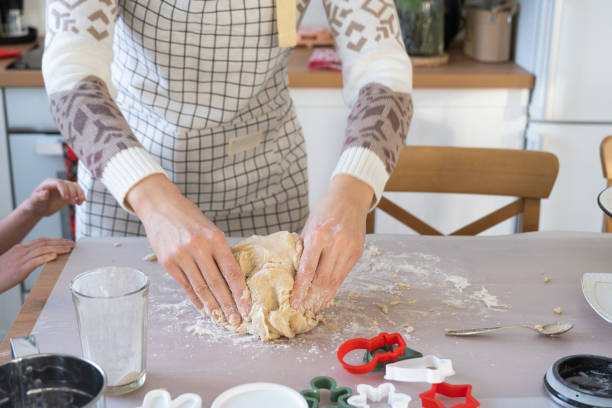 istock Hands knead thick dough on the kitchen table, decorated with festive decorations for Christmas and New year. Baking at home, aroma and comfort. Close-up 1460159331