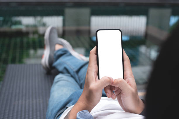istock Mockup image of mobile phone for advertising. Mock up image of man hand holding and using smartphone with blank screen for mobile app design or text advertisement 1460162015