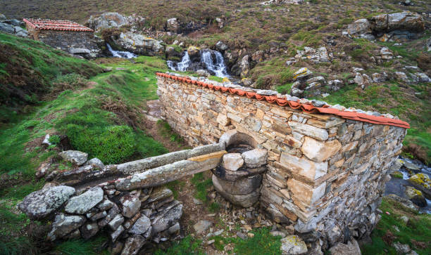 Old small stone grain mills with flume on a creek on the north Spanish coast - Muíños de Ardeleiro stock photo