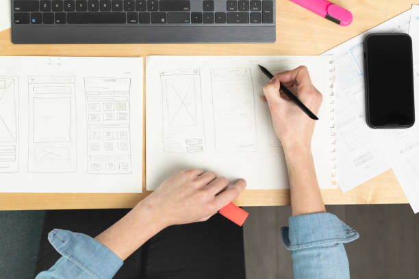 istock Sketch of wireframe for website. Women designer working on a mobile application, drawing on paper. 1460162331