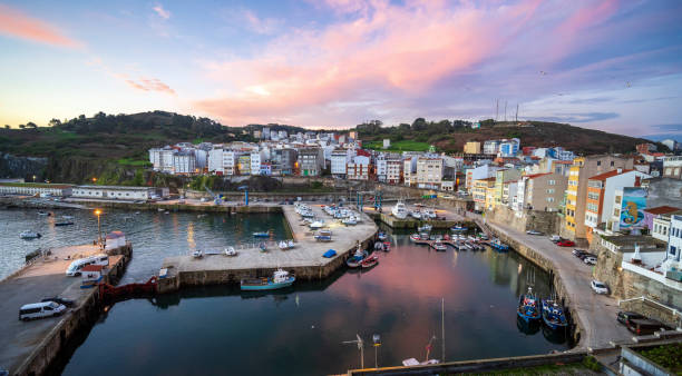 Malpica, Spain harbor at sunrise with pink clouds and fishing boats stock photo