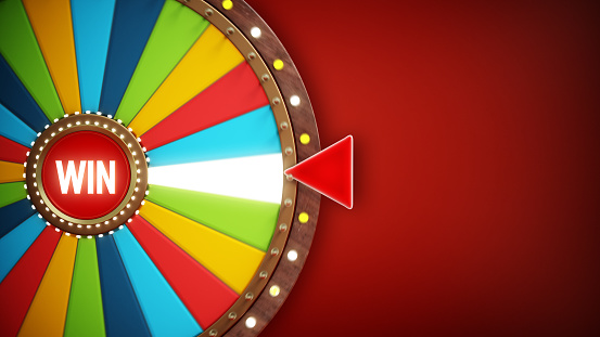 Multi-colored turning prize wheel on dark red, vignette background. Copy space on the right.