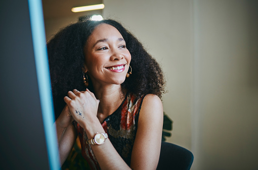 Black woman, thinking and computer in office with smile for social media marketing, data and happy for success. Woman, digital marketing expert and pride at pc for analytics, focus or career goals