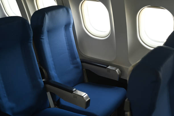 istock Airplane cabin interior, empty comfortable seats in economy class with portholes. 1460167466