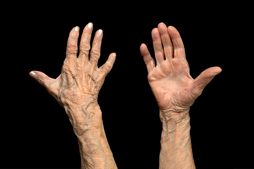 Elderly female's hands on black background