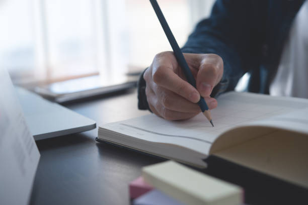 istock Event planner timetable agenda plan on year 2023 schedule event. Business woman checking timetable, taking note on calendar planner notebook on office table. Calendar event plan, work planning, closeup 1460169136