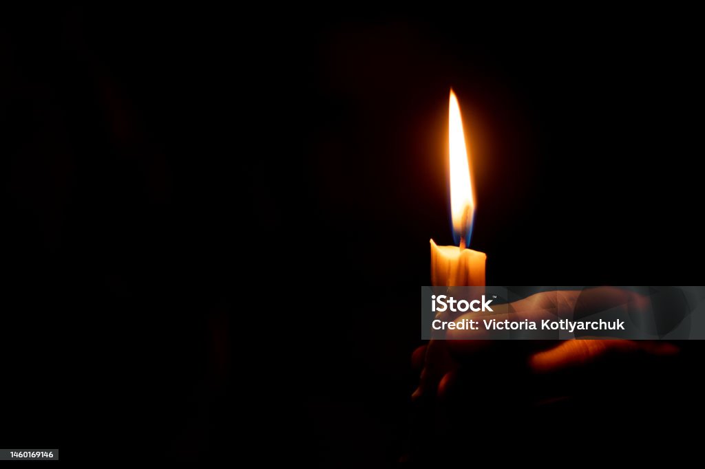candle flame illuminates a female hand in a dark room candle flame illuminates a female hand in a room Candle Stock Photo