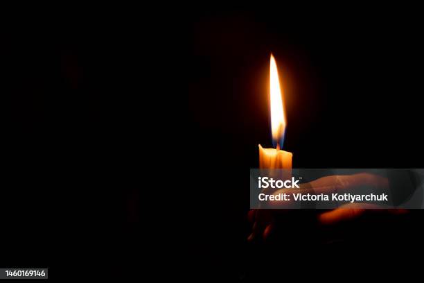Candle Flame Illuminates A Female Hand In A Dark Room Stock Photo - Download Image Now