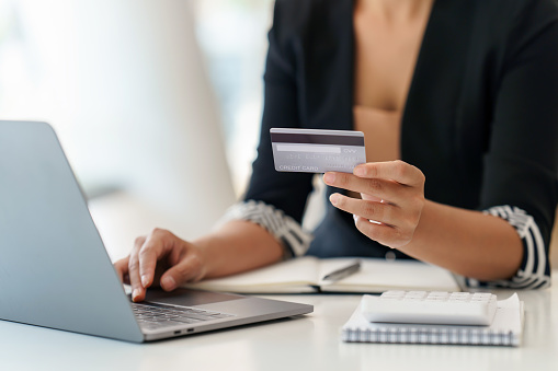 Businesswoman hand holding credit card and using laptop. Close up of female shopping online with credit card. Online Payment.