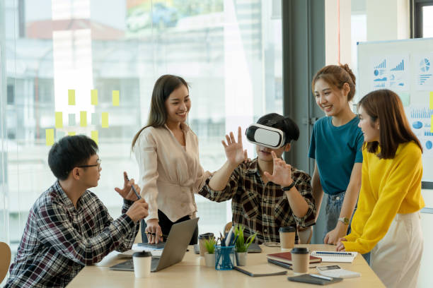 istock Group of young Asian business people using virtual reality glasses during meeting testing virtual reality headset and exchange project ideas shared to improve the visual experience. 1460175243