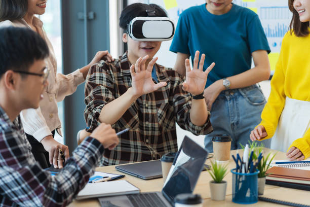 istock Group of young Asian business people using virtual reality glasses during meeting testing virtual reality headset and exchange project ideas shared to improve the visual experience. 1460175245