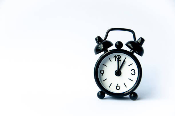 istock Black alarm clock pointing at 1 o'clock with customizable space for text on white background. Copy space and time concept. 1460175521