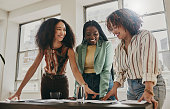 istock Teamwork, collaboration and planning black women with documents, paperwork or design strategy in office. Business startup, gender equality and marketing ideas of diversity people in workspace meeting 1460179345