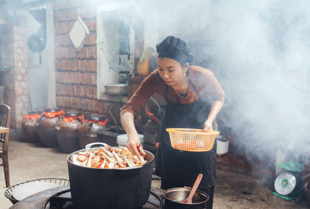 istock young vietnamese woman cooking steamed fish on open fire in restaurant 1460180150
