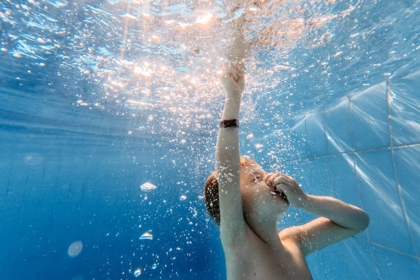 istock Little boy diving with closed eyes in swimming pool. 1460182340