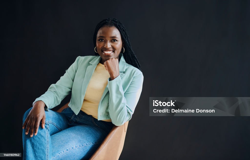 Confident, happy and portrait of black woman isolated on dark background sitting in chair for success and hr mockup. Human Resources, empowerment and smart person smile with studio mock up or space Women Stock Photo