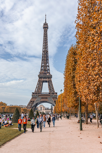 Eiffel Tower with tourists visiting the Champ de Mars public garden in Autumn in Paris, France