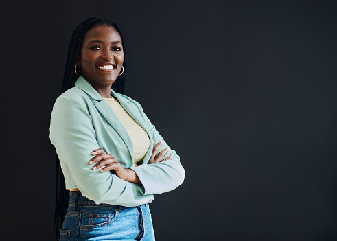 Proud, happy and portrait of black woman with arms crossed isolated on a black background. Success, smile and beautiful expert African girl with confidence and mockup space on a studio background