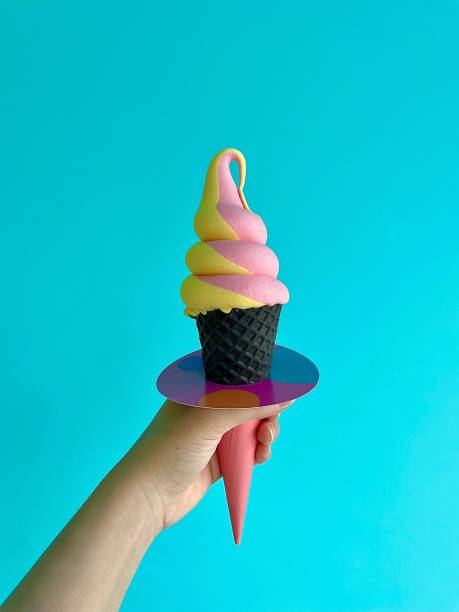 Human hand holding sweet colorful ice-cream on blue background