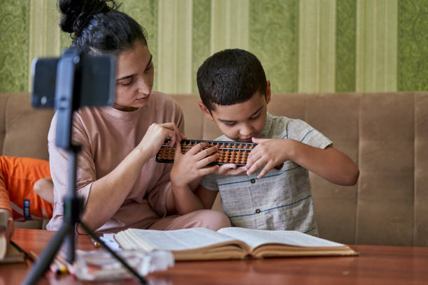 istock Young female teacher explaining the math lesson during an online class with a male pupil at home 1460190262