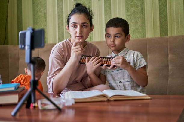 istock Young female teacher explaining the math lesson with a young pupil during an online class 1460190284