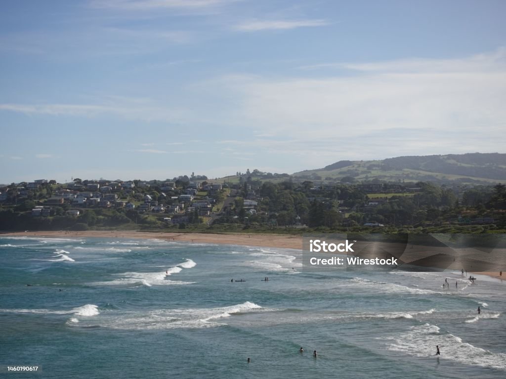 People resting on the sandy beach and swimming in the blue ocean in Kiama town on a sunny day The people resting on the sandy beach and swimming in the blue ocean in Kiama town on a sunny day Beach Stock Photo