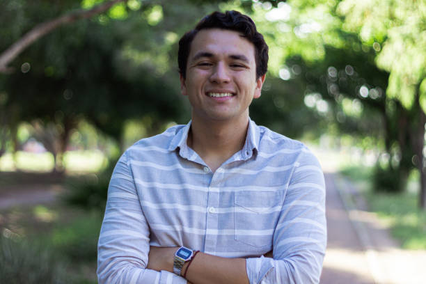 istock Hispanic male smiling happily in a park 1460191530