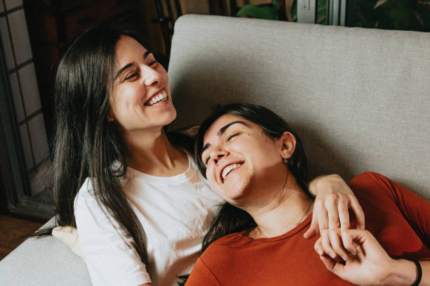 istock Lesbian couple having fun on the couch of their flat while hugging each other with love 1460194507