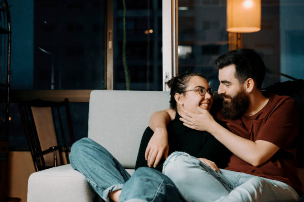 istock Shallow focus of two Caucasian lovers cuddling on a sofa and sharing a romantic time together 1460195111