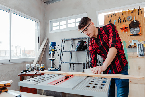 A caucasian male carpenter working in a workshop