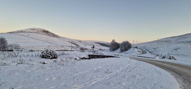 istock Panoramic view of a mountain range covered with snow during an orange sunset 1460196225