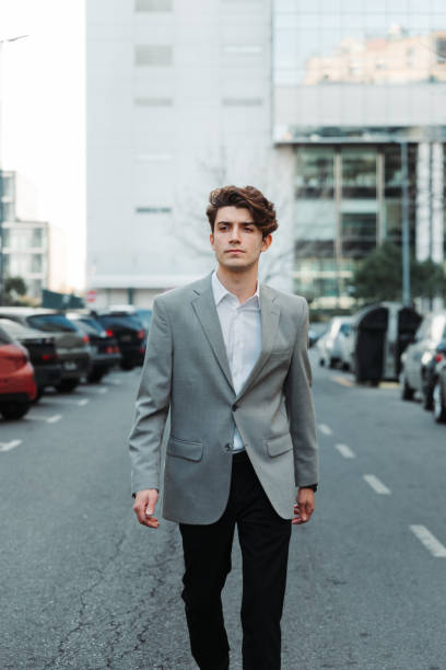 istock Young man in a suit walking in the street 1460196383