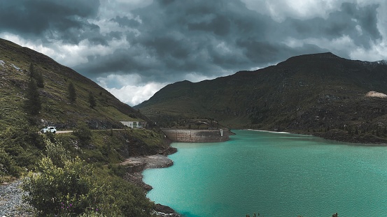 The turquoise river and mountains against the background of the cloudy sky.