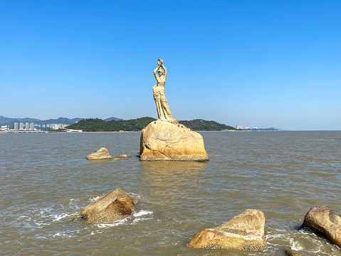 December 25, 2022: Zhuhai, Guagndong, China: Zhuhai is one of the four Special Economic Zones established by Chinese Government. It is localted in the mouse of Zhu River and on the opposite of Macau. Here is the statue of  Zhuhai Fishing Girl.