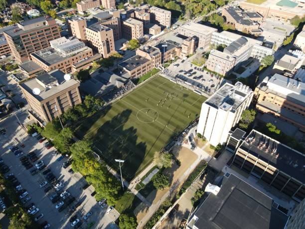 istock Drone shot over soccer field between buildings on sunny day 1460198478