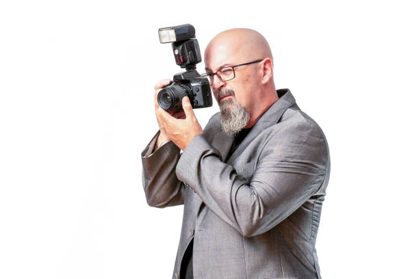 istock Bearded bald male with a professional camera standing against an isolated white background 1460198686