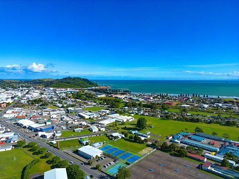 A beautiful view of the city of Gisborne in New Zealand with buildings on the green field under the clear, blue sky