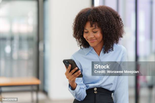 Business Black Woman Having Phone Conversation With Client In Office African American Young Woman Using Smart Phone Stock Photo - Download Image Now