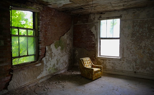 A view of a yellow armchair inside an old abandoned building