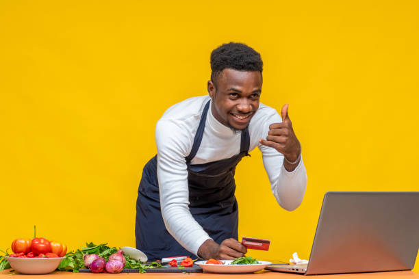 istock African male chef using his laptop while preparing food in front of a yellow wall 1460201738