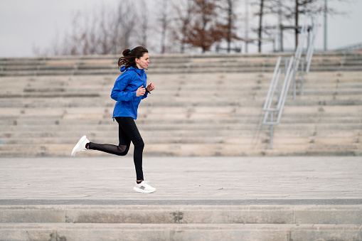 A young Caucasian female jogger running in the morning