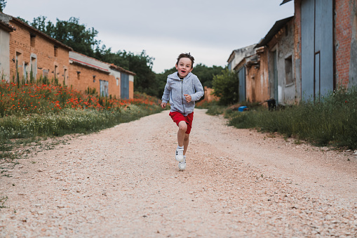 The little boy running happily outdoors.