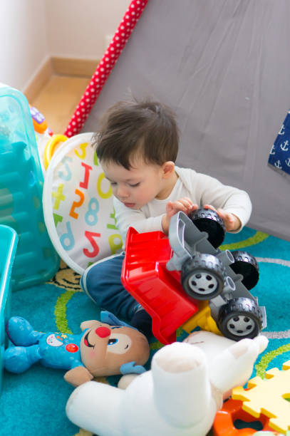 istock Cute little boy playing with a toy car at home 1460204524