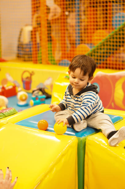 istock Cute baby boy playing with plastic balls in a play room 1460204654