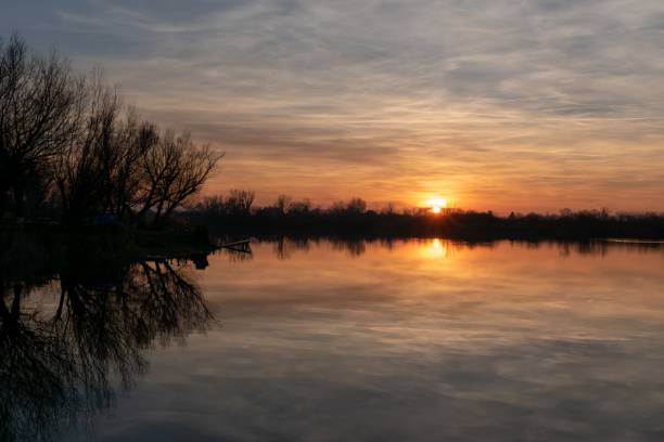 istock Crystal clear lake reflecting trees in the forest during scenic sunset 1460207240