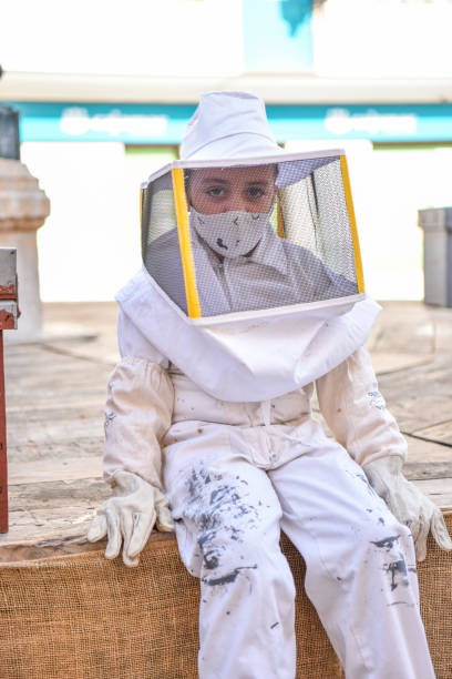 養蜂家として装備された女の子の接写で、養蜂場に行く準備ができています。 - children only healthy lifestyle vertical close up ストックフォトと画像